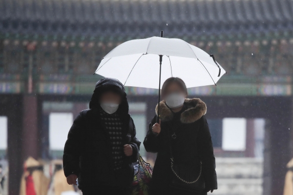 서울 지역에 비가 내리고 있는 21일 오후 서울 종로구 경복궁에서 우산을 쓴 시민들이 걷고 있다. 2021.01.21. [뉴시스]
