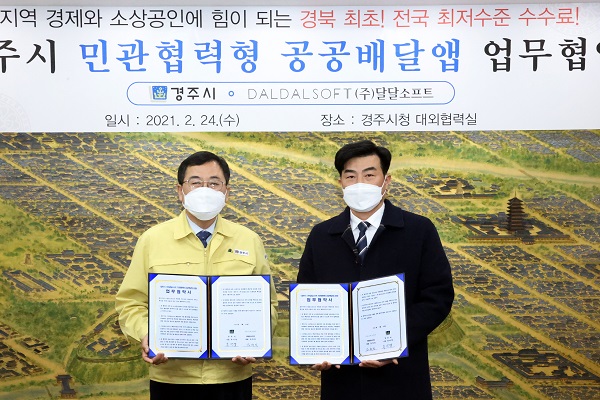 주낙영 경주시장(왼쪽)과 김정민 ㈜달달소프트 대표가 24일 민관협력형 공공배달앱을 도입하기 위한 업무협약을 체결하고 기념사진을 찍고 있다