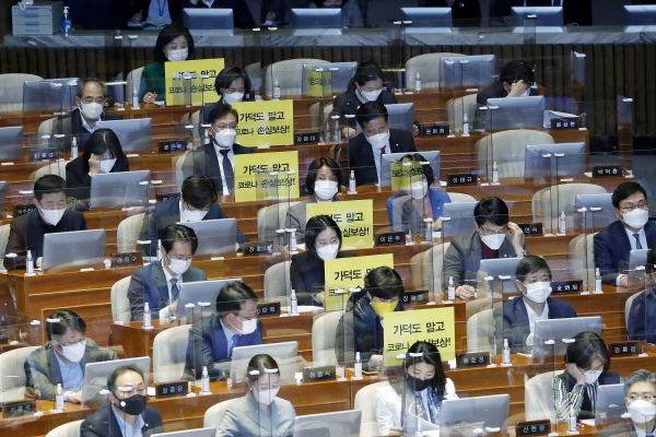 정의당 의원들이 26일 서울 여의도 국회 본회의에서 가덕도 관련 법안을 비판하는 피켓을 의석에 붙여 놓고 있다. [뉴시스]
