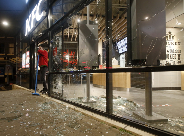 지난 1월25일(현지시간) 네덜란드 로테르담에서 코로나19 통금 반대 시위로 식당의 유리창이 부서진 모습. [뉴시스]