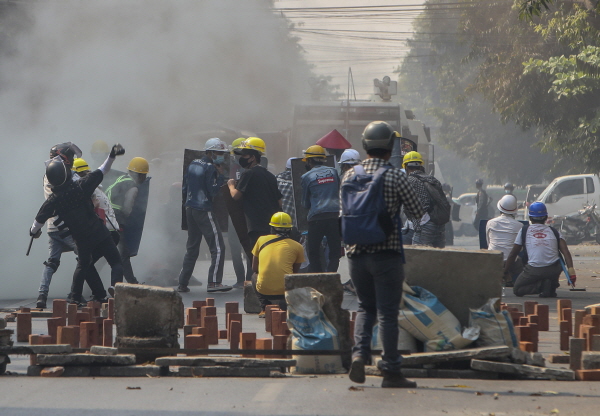 지난 3일 미얀마 만달레이에서 군부 쿠데타 반대 시위대가 임시 구조물을 방패 삼아 경찰이 발사한 최루탄에 맞서고 있다. [뉴시스]