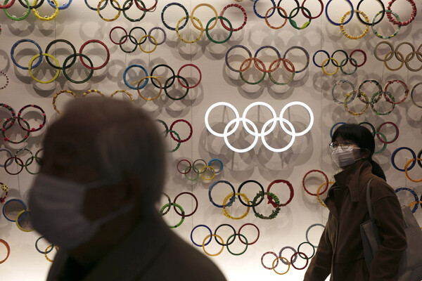 23일 마스크를 낀 시민들이 일본 도쿄의 올림픽 박물관을 지나고 있다. 신종 코로나바이러스 감염증(코로나19) 확산 속도가 높아지는 가운데 국제올림픽위원회(IOC)가 7월 일본에서 개최 예정된 도쿄올림픽의 취소 가능성을 제기했다. [뉴시스]