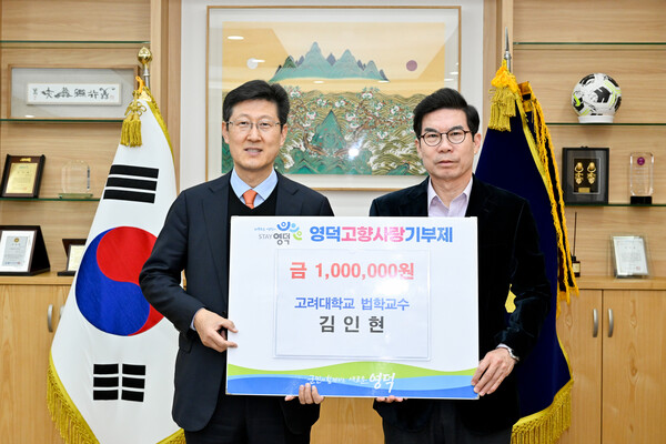 김인현 교수(왼쪽)가 영덕군을 찾아 김광열 영덕군수에게 고향사랑기부금 100만원을 전달했다.