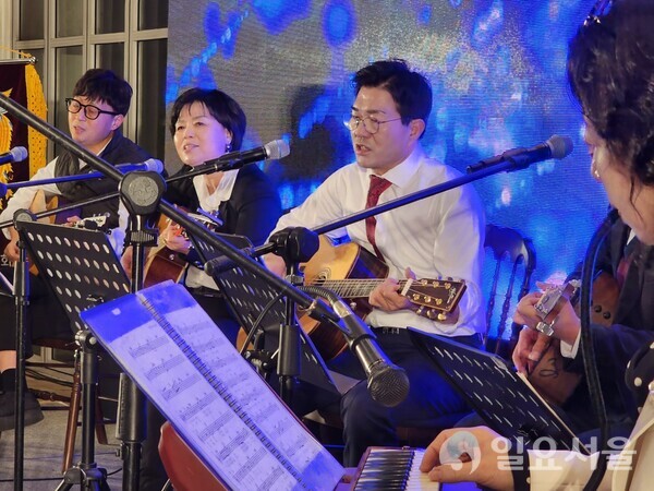 윤소식 전 청장(가운데)과 통기타 동호회 회원들이 참석한 관람객들에게 노래와 기타연주를 선보이고 있다.[사진=이재희 기자]