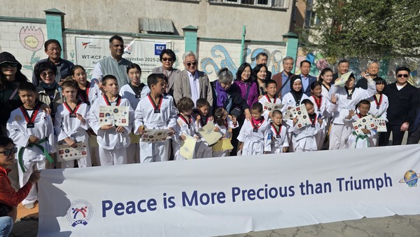 2025 WT-한문화재단 케어스 프로그램을 후원한 한문화재단(이사장 김준일)이 마련한 텀블러를 엘미라 쥬마에바 아이다넥 고아원장에게 전달하고 태권도복 차림의 원생들을 격려했다.[사진=GCS]