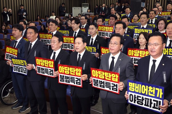 장동혁 국민의힘 대표와 송언석 원내대표를 비롯한 의원들이 11월 4일 오전 서울 여의도 국회에서 열린 의원총회에서 야당탄압과 불법특검을 규탄하는 손피켓을 들고 구호를 외치고 있다.[뉴시스]